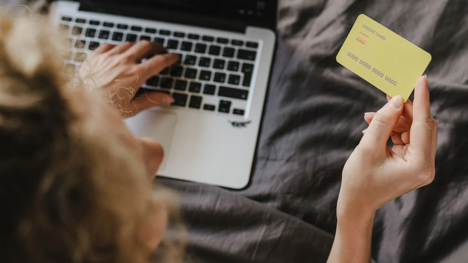Contrato de prestação de serviços de Google Ads: modelo 1 Pessoa segurando cartão de pagamento diante do notebook, representando a verba de anúncios