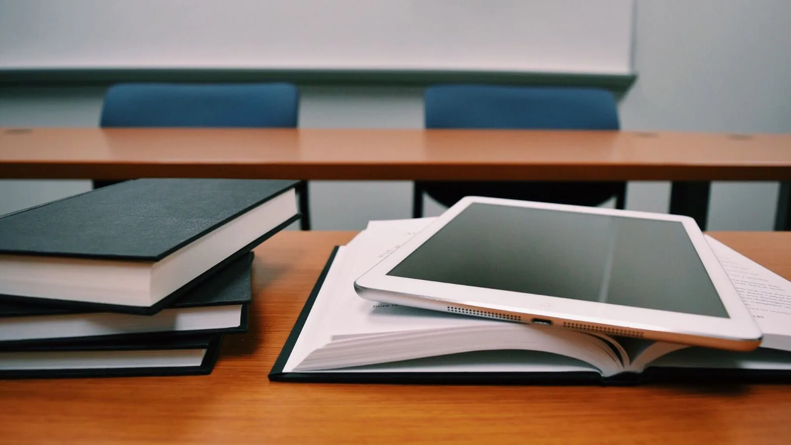 Tablet sobre livros e documentos em mesa de madeira
