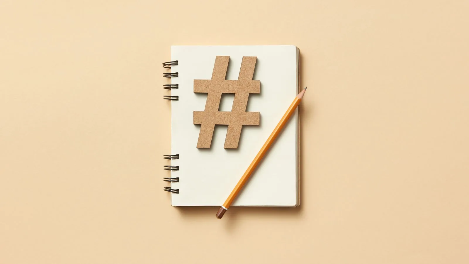 Modelo de contrato de gestão de redes sociais 2 Caderno com símbolo de hashtag e lápis sobre fundo bege