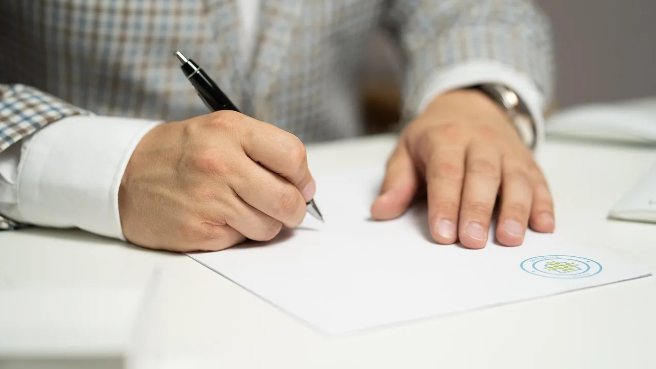 Homem assinando contrato impresso sobre mesa branca, representando a formalização da terceirização