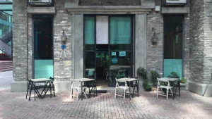 Fachada de cafeteria com mesas na calçada, representando o pequeno negócio que precisa proteger a marca