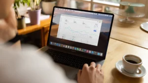 Pessoa trabalhando em notebook com xícara de café ao lado, representando o freelancer que trabalha por conta própria