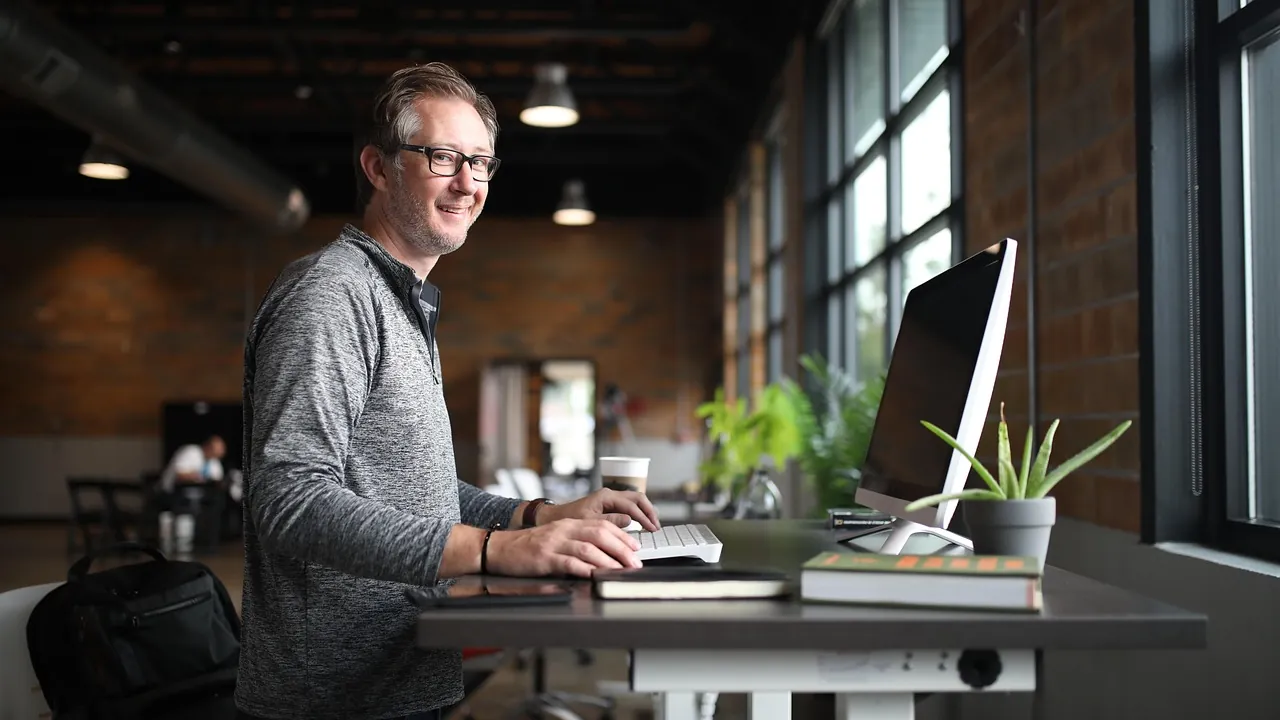 Quando o freelancer passa a ter vínculo de emprego? 1 Profissional trabalhando em uma estação de trabalho dentro do escritório, representando a rotina que pode caracterizar vínculo de emprego