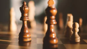 Peças de xadrez de madeira em close, representando a disputa entre empresas concorrentes