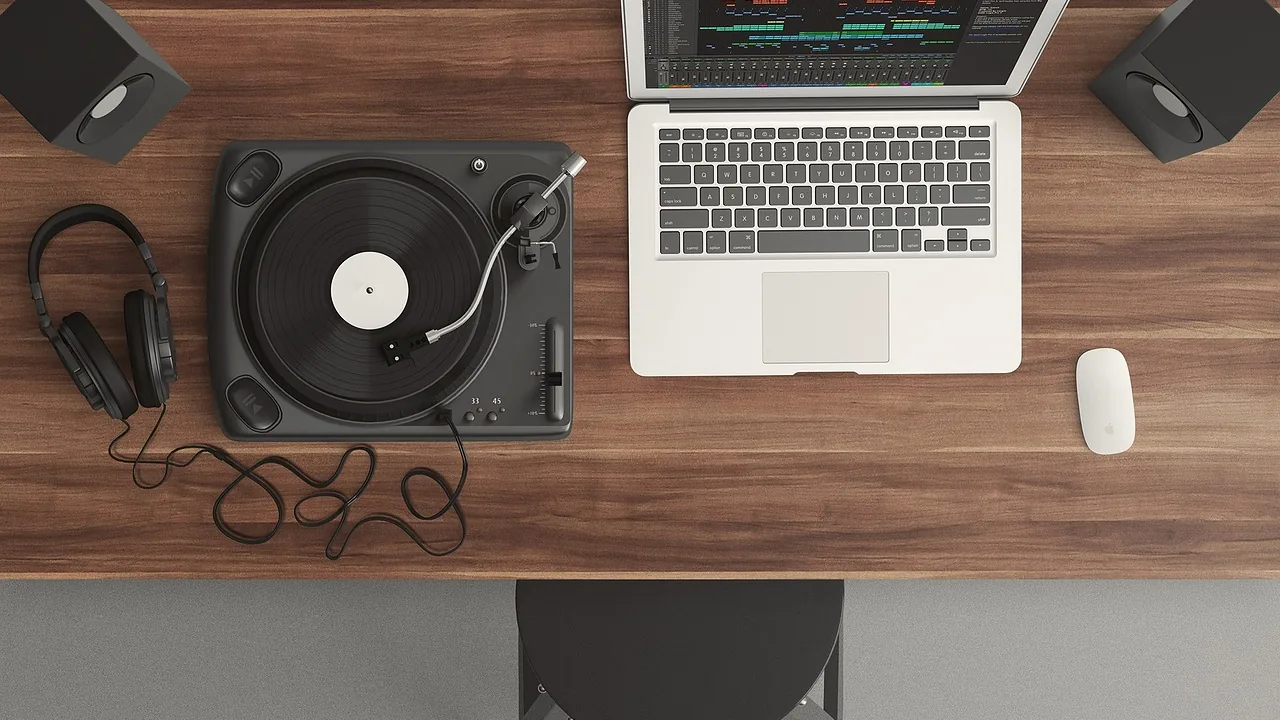 Modelo de ação de indenização por plágio musical. 2 Mesa de trabalho com toca-discos, fones de ouvido e notebook, representando a análise da gravação