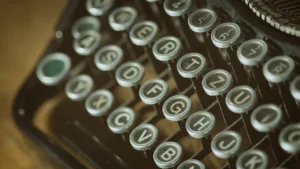 Teclas antigas de máquina de escrever em close, representando a autoria de textos