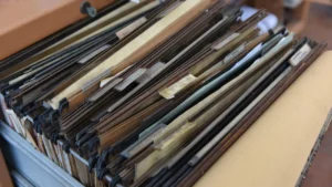 Gaveta de arquivo com pastas suspensas, representando os documentos confidenciais protegidos pelo NDA