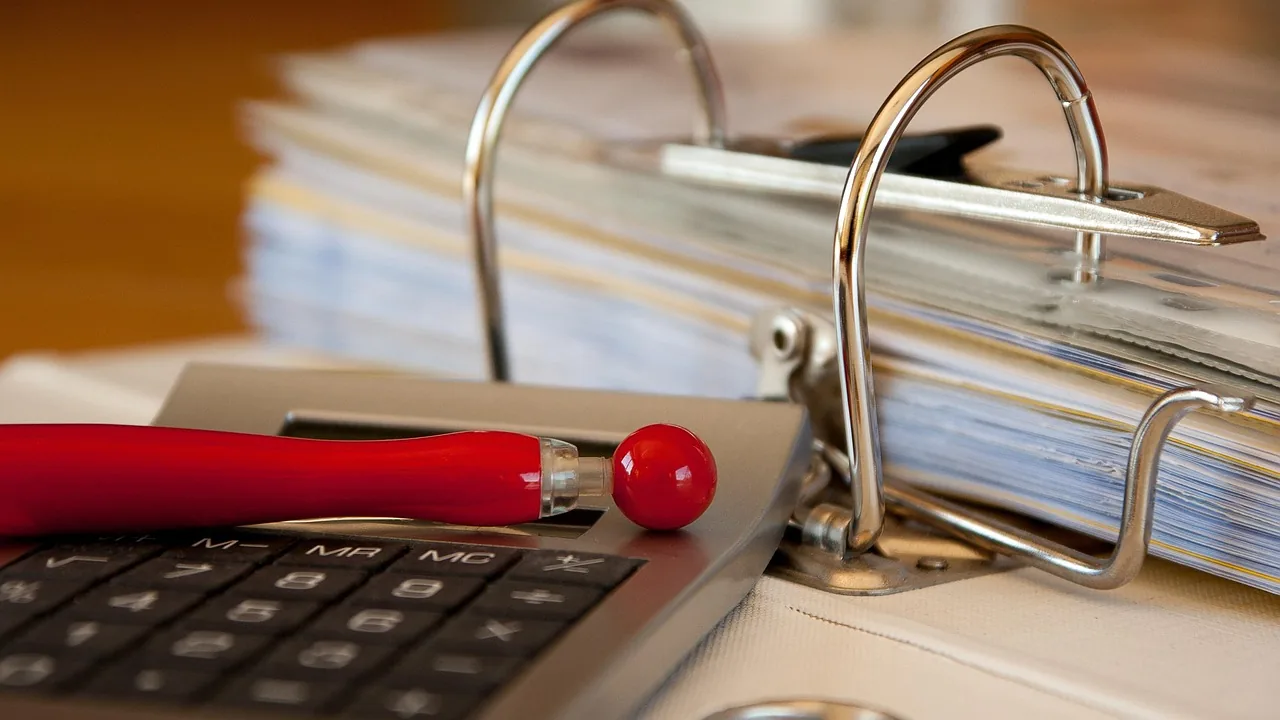 Modelo de Petição de Rescisão Contratual por Falta de Pagamento. 2 Fichário com faturas e calculadora, representando a cobrança dos valores em atraso